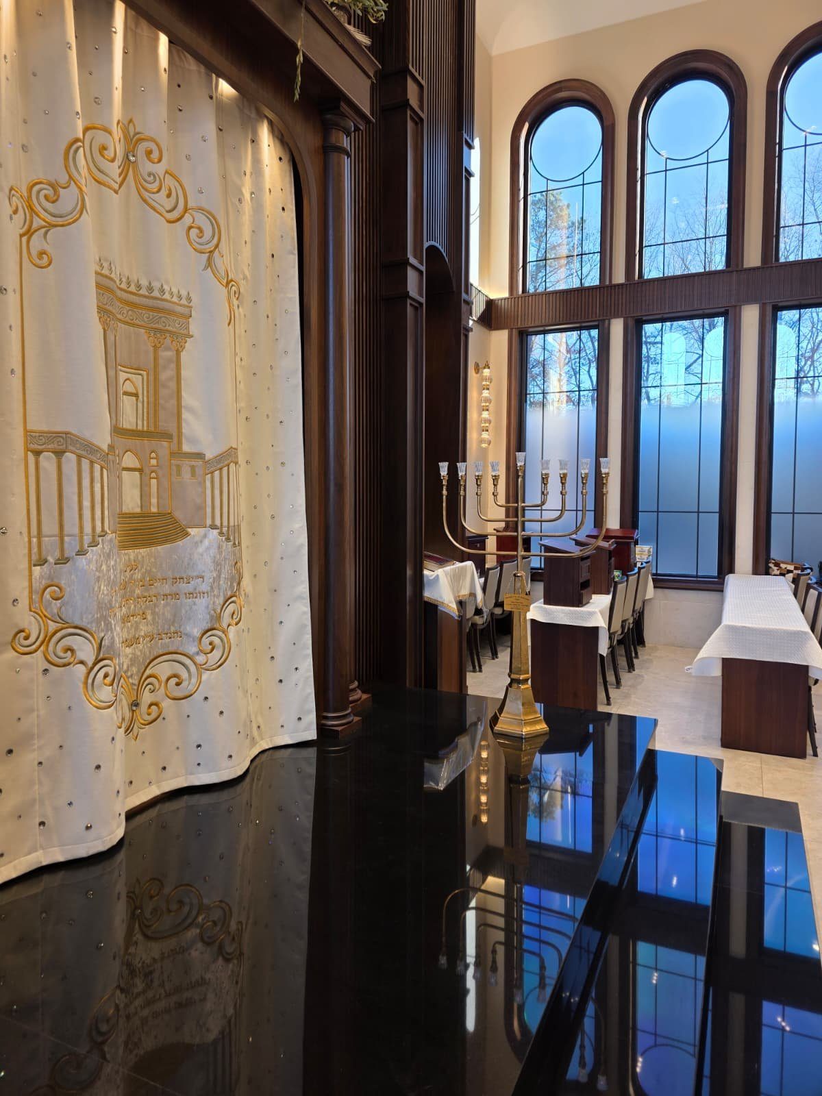 Finished sanctuary interior with arched leaded-glass windows and tall divided-lite windows in dark wood frames