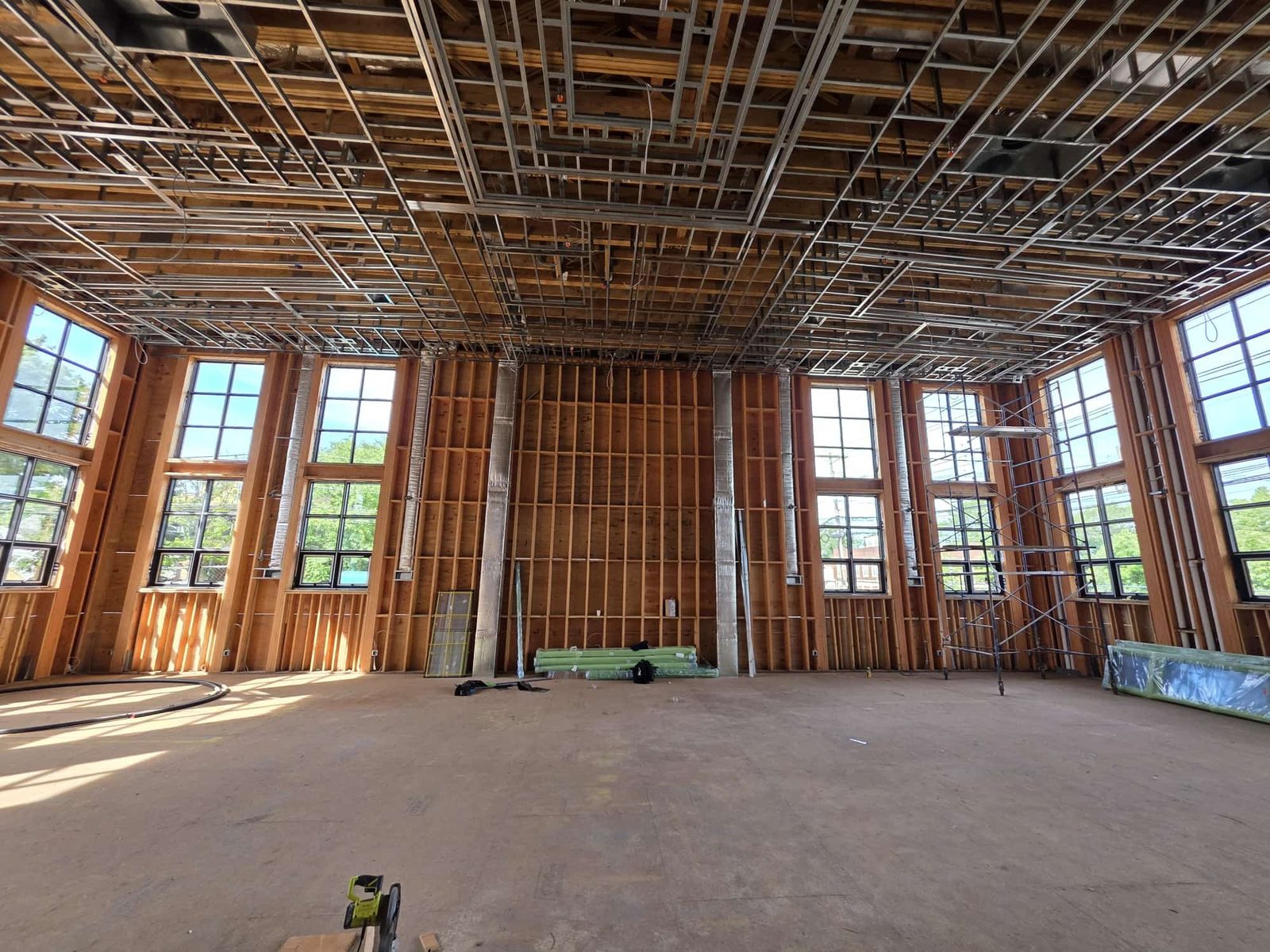 Large double-height hall with two-story divided-lite black windows on both side walls